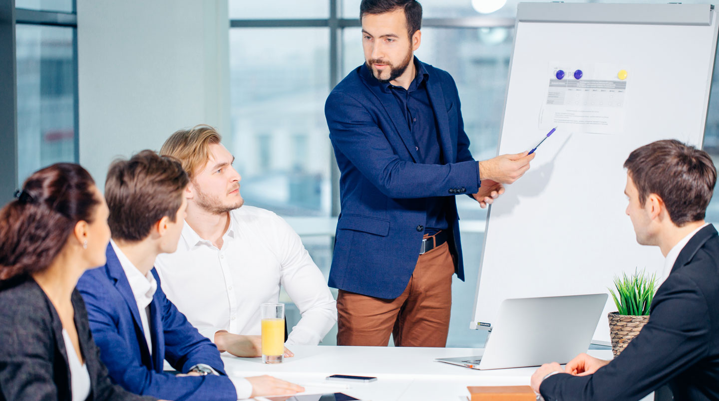 Un formateur donnant un retour direct à un apprenant lors d'une session de coaching commercial en petit groupe