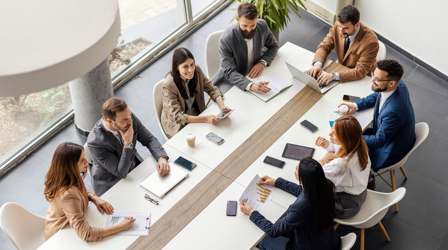 Deux petits groupes de managers en atelier de travail collaboratif avec tableaux muraux dans une salle moderne et lumineuse